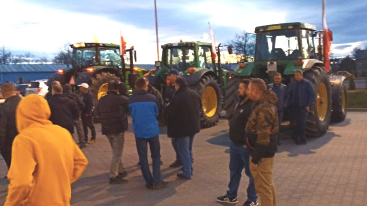 mai multe persoane si tractoare in parcare