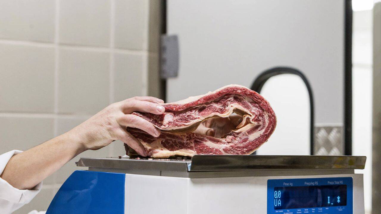 o persoana care cantareste o bucata de carne