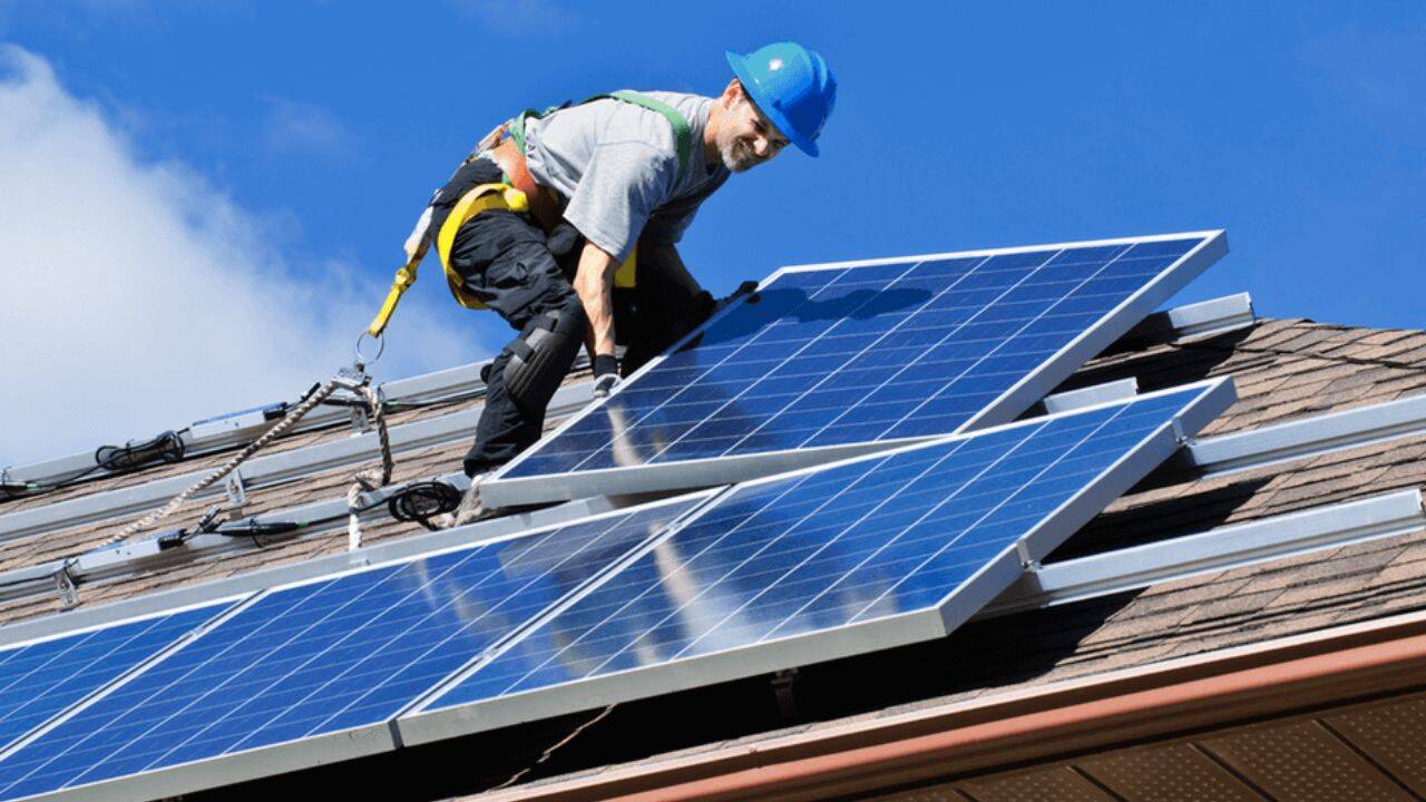 o persoana care monteaza panouri pe acoperis